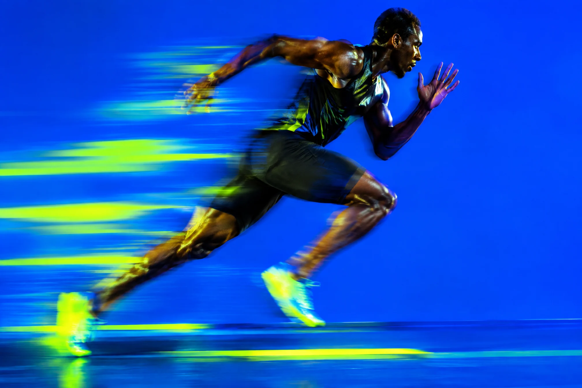 Sprinter in motion blur against electric blue with lime light streaks