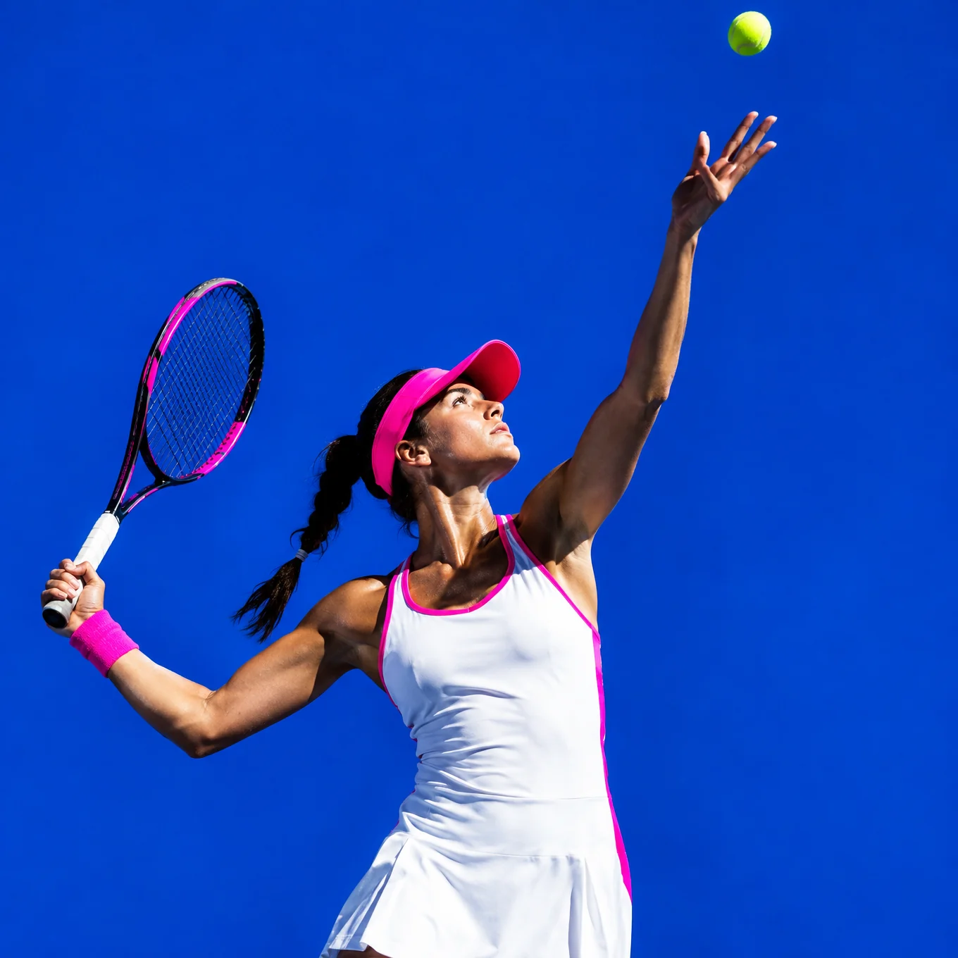 Tennis player tossing the ball to serve against electric blue
