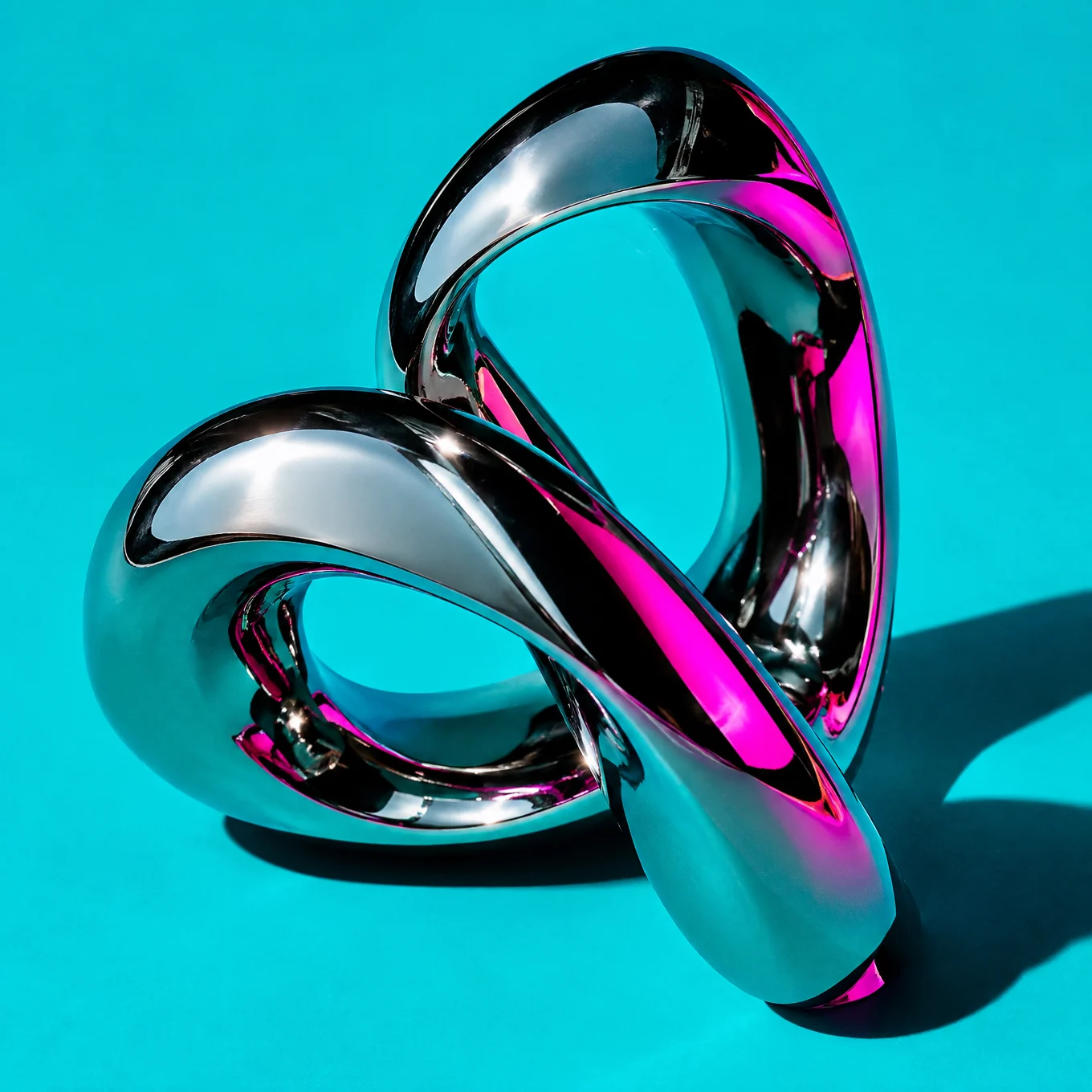 Interlocking chrome sculpture on turquoise with magenta reflections